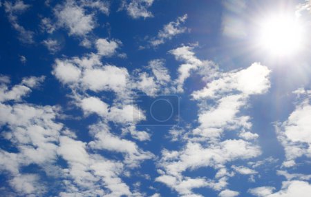 Lumière brillante du soleil sur un ciel bleu foncé parmi les nuages. Vue spectaculaire sur le soleil.