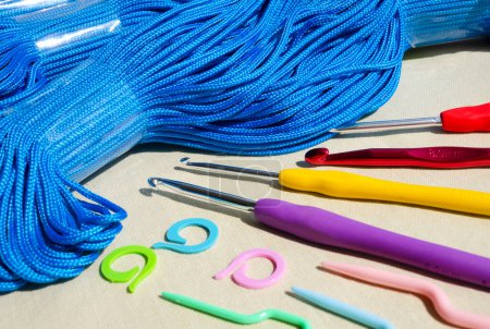 Blue polyester cord and knitting accessories. Synthetic cord, marker, hook for knitting bags and baskets.