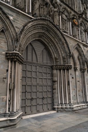 Arch Entrance of Nidaros Cathedral in Trondheim, Norway. The wooden arched doors and stone carving ornate off Nidaros Cathedral, reflecting Trondheim rich architectural heritage.