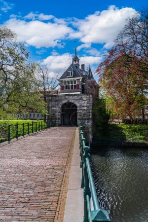 Vista de la arquitectura renacentista Puerta de la ciudad de Oosterpoort desde la edad de oro y el puente contiguo en la ciudad holandesa de Hoorn bajo un cielo de nubes azules.