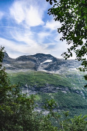 Looking up the towering peaks of Kaldfonna mountain, rugged rocky terrain with snow remnants in summer near Sunndalsora, Norway