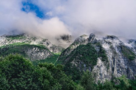 Schroffes Gelände im Trollheimen-Gebirge in Zentralnorwegen. Niedrige Wolken streicheln die felsigen, steilen, baumbestandenen Klippen von Trollheimen, die Berggipfel sind in Wolken gehüllt