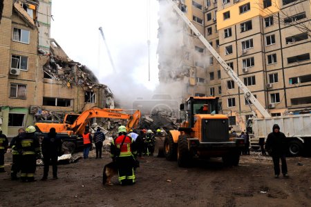 Photo for Russian missile strike destroyed residential building, Dnipro, Ukraine. Rescuers are looking for people under rubble of house, rescue equipment, fire. Russian war in Ukraine, Dnepr 2022-01-15 - Royalty Free Image