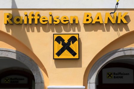 Photo for Raiffeisen Bank in medieval town. Signboard and flags large international Raiffeisen Bank are located in Cesky Krumlov, Czech Republic, 2022-06-14 - Royalty Free Image