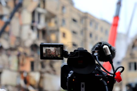 Foto de Una cámara de televisión profesional transmite en vivo cerca de casa destruida por cohete ruso en la ciudad de Dnipro. Transmisión en vivo de la agencia de noticias Reuters. Guerra de Rusia contra Ucrania, Dnipro 2023-01-15 - Imagen libre de derechos