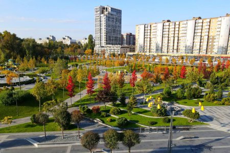 Schöner Herbstpark mit malerischen gelben Orangenbäumen und Blättern. Herbstliche Straßen in der Stadt Dnipro, Ukraine