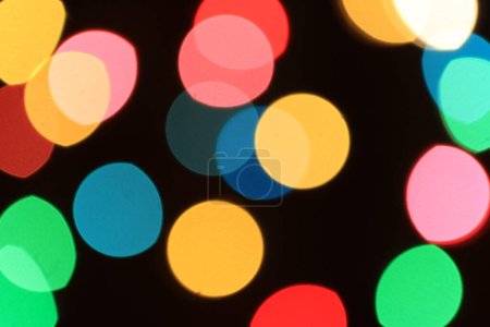 Foto de Luces borrosas de noche, noche, iluminación de Navidad de Año Nuevo, bokeh redondo desenfocado rosa, amarillo, rojo y azul, fondo abstracto - Imagen libre de derechos