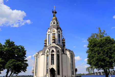 Hermosa iglesia cristiana ortodoxa blanca cerca del río en Dnipro, Ucrania, primavera, paisaje urbano de verano
