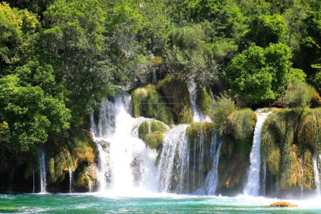 Kaskadowy wodospad wśród dużych kamieni w Parku Krajobrazowym Krka, Chorwacja wiosną lub latem. Najpiękniejsze chorwackie wodospady, góry i przyroda.