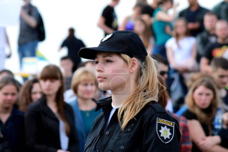 Foto de Una hermosa chica patrulla oficial de policía está parada en la calle. Mujer policía en uniforme, caballero y signo de la policía ucraniana en Dnipro, Ucrania, 2016-05-21. - Imagen libre de derechos