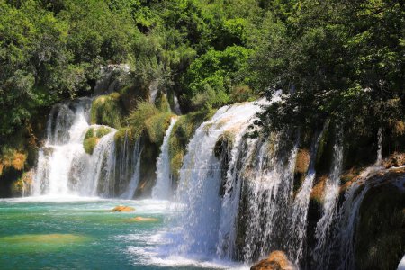 Photo for A cascade waterfall among large stones in Krka Landscape Park, Croatia in spring or summer. The best big beautiful Croatian waterfalls, mountains and nature. - Royalty Free Image