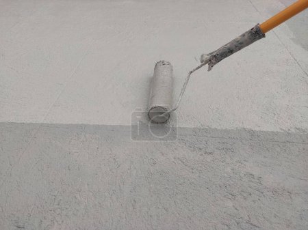 Photo for Waterproofing a building using a paint roller - Royalty Free Image