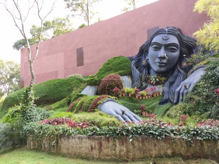 Lady statue whose decorations are made of flower pots. Sculpture of a woman lying near Siri cafe near Chikmagalur, India