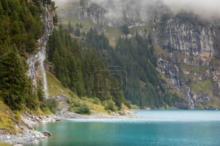 Photo for Misty Oeschinensee, Oeschinen lake, on Bernese Oberland swiss alps, Kandersteg, Switzerland - Royalty Free Image