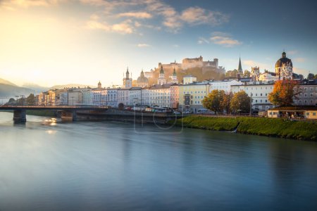 Beautiful view of Salzburg cityscape from Salzach River at misty sunrise, Austria