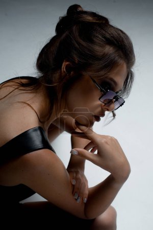 Téléchargez les photos : Portrait de jeune femme à la mode posant en studio - en image libre de droit
