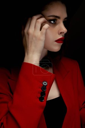 Foto de Young girl in a hat and a red jacket poses in the studio - Imagen libre de derechos