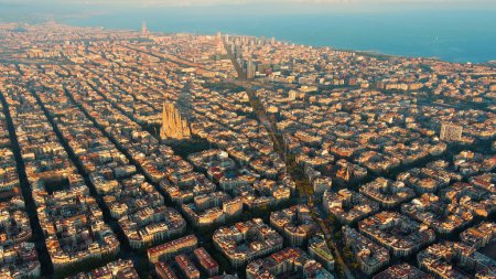 Aerial view of Barcelona city skyline, Basilica Sagrada Familia and Eixample residential urban grid at sunset, Catalonia, Spain