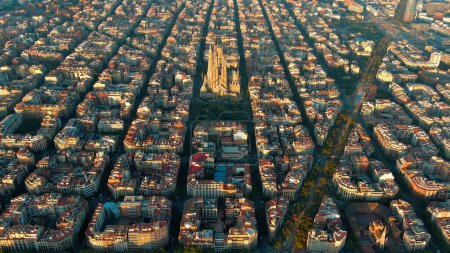 Vista aérea del horizonte de la ciudad de Barcelona, Basílica Sagrada Familia y Eixample red urbana residencial al atardecer, Cataluña, España