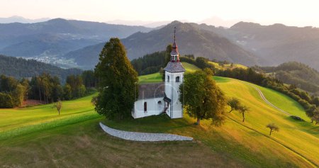 Luftaufnahme der Thomaskirche auf einem Hügel, Sonnenaufgang, Skofja Loka, Slowenien