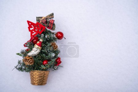 Téléchargez les photos : Sapin de Noël avec des décorations, des ornements et des branches de sapin avec des jouets sur fond blanc neige. Fêtes festives, Nouvel An heure d'hiver - en image libre de droit