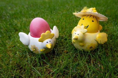 huevos de Pascua de colores lindos en titular de cerámica de pollo sobre fondo verde. Feliz celebración de Pascua