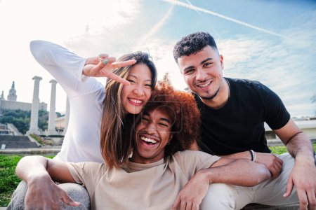 Photo for Group of young multiracial friends hugging and having fun together. Three happy cool buddies smiling and looking at camera. Diverse joyful student teenage people laughing bonding outside at weekend - Royalty Free Image