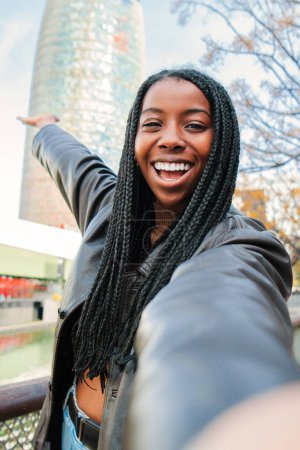 Foto de Vertical individual de cerca retrato de una chica feliz tomando una selfie. vista de pantalla de una joven afroamericana con trenzas sonriendo teniendo una videollamada con un dispositivo de teléfono inteligente. Alta calidad - Imagen libre de derechos