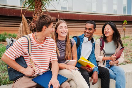 Photo for Group of multiracial young academic students talking together sitting at university campus. Classmates having a friendly conversation at highschool. Portrait of happy teenagers laughing and having fun - Royalty Free Image