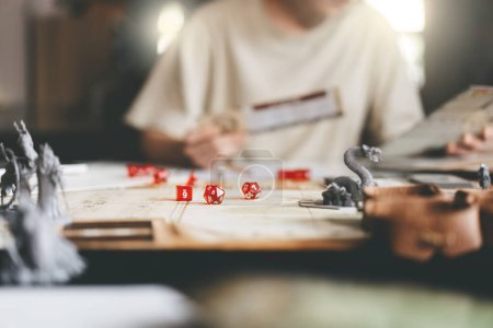 Photo for Role playing tabletop and board games hobby concept. Focus on dice d20. Blur background with people and monster miniatures. - Royalty Free Image