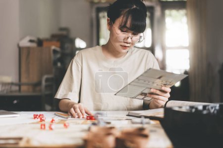 Photo for Role playing tabletop and board game hobby concept. Young adult asian woman enjoying with storytelling. Blur foreground with monster miniatures and dice component. - Royalty Free Image