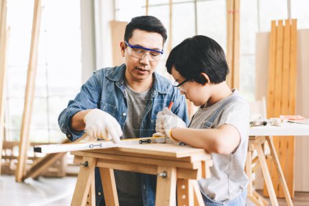Photo for Southeast asian family father and son diy activity together at home concept. Dad teach using tools about carpenter skill with child at workshop. - Royalty Free Image