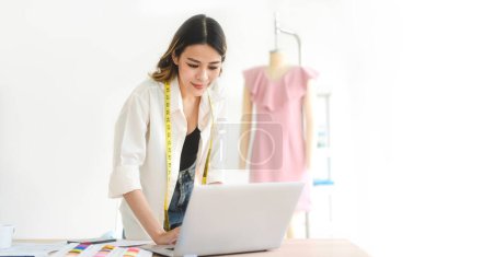 Photo for People working in fashion design concept. Young adult asian woman designer using laptop computer for online social media marketing. Banner size background. - Royalty Free Image