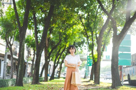 Photo for Young adult southeast business asian woman walking on footpath public park outdoor. People break in city after working relax in nature environment for healthy lifestyle. - Royalty Free Image