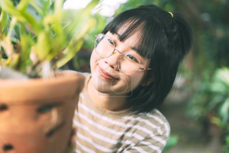 Photo for Portrait of young adult asian woman lifestyle at home. Leisure people walking in garden at backyard on day. Wellness happy face wear eyeglasses. - Royalty Free Image