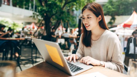 Photo for Business freelancer adult asian woman using laptop computer for work at sidewalk cafe. Happy and smile face. Urban people lifestyle with modern technology on day. - Royalty Free Image