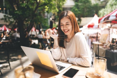 Photo for Business freelancer adult asian woman using laptop computer for work at sidewalk cafe. Happy and smile face. Urban people lifestyle with modern technology on day. - Royalty Free Image