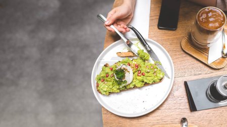 Photo for Guacamole avocado healthy food top on bread toast. Asian woman background at outdoor restaurant on day. City people lifestyle on weekend concept. Banner size background. - Royalty Free Image