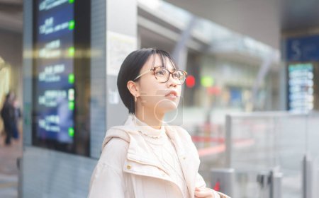 Photo for Portrait of city lifestyles young adult asian woman waiting at bus terminal. Japanese tokyo city girl fashion short hair style with eyeglasses. - Royalty Free Image