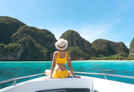 Foto de Vista trasera de la mujer turista sentarse en el barco de vela llevar bikini cielo azul y el mar. Viaje de lujo al sudeste asiático famosa isla de destino en vacaciones de verano. Tailandia, Bahía Maya, Ko Phi Phi - Imagen libre de derechos
