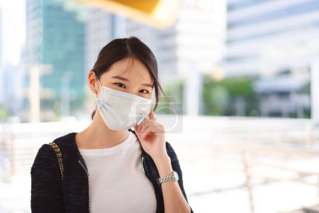 Photo for Happy young adult business asian woman wear face mask for protect virus corona or covid19 and air pollution. Urban people lifestyle with public health on day concept. Women portrait looking camera. - Royalty Free Image