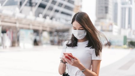 Téléchargez les photos : Young adult business asian woman wear face mask for protect virus corona or covid19 and air pollution. Urban people lifestyle with public health on day concept. Women portrait looking camera. - en image libre de droit