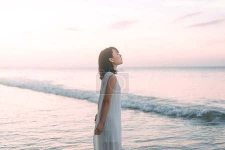 Téléchargez les photos : Portrait de femme asiatique à la plage repose dans les vagues de la mer vibes esthétiques. Les gens se détendent dans la nature concept. - en image libre de droit