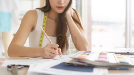 Photo for Closeup beautiful hand young adult women designer sketching idea with pencil. Workplace table art of fashion design in action. - Royalty Free Image