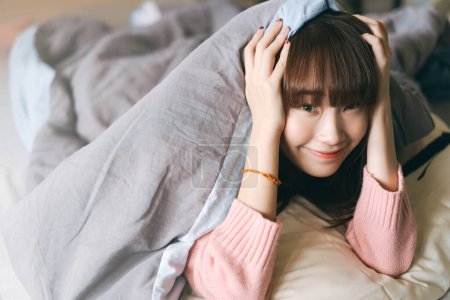 Photo for Portrait young asian cute woman teen college student. Girl in bedroom after wake up stay at home with eye attractive. Has long hair and wear pink sweater. - Royalty Free Image
