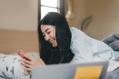 Photo for Lifestyle with modern technology concept. Happy young adult lonely single woman using smartphone in the moring for social message app chat with friend for mental health. - Royalty Free Image