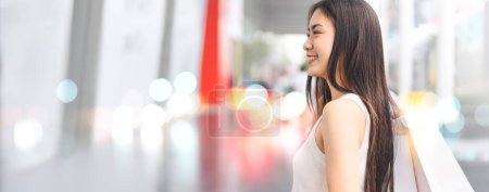 Photo for Elegant people city lifestyles with buying consumerism. Young beautiful face asian woman shopping bags. Happy face standing at outdoor banner size with copy space. - Royalty Free Image