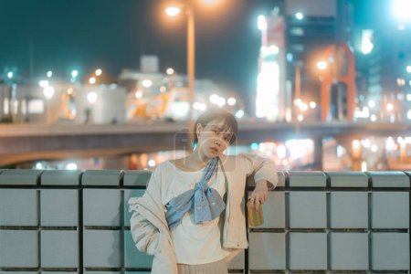 Téléchargez les photos : Portrait de la vie nocturne de la ville personnes asiatiques. Japonais tokyo ville seule jeune femme adulte boire de la bière peut. Fond urbain avec néon bokeh lumière. - en image libre de droit
