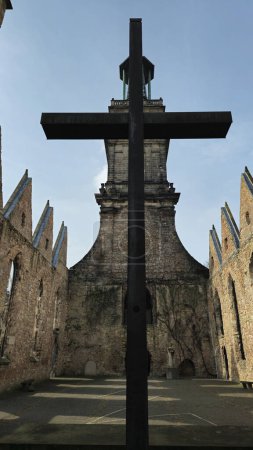 A massive cross stands in front of a decrepit building, showcasing a blend of medieval architecture and modern symbol in the city skyline Hanover Germany