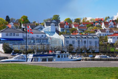 Téléchargez les photos : Une vue sur les yachts de mer dans le port et les maisons résidentielles et autres bâtiments dans la petite ville portuaire d'Asgardstrand, Norvège. - en image libre de droit